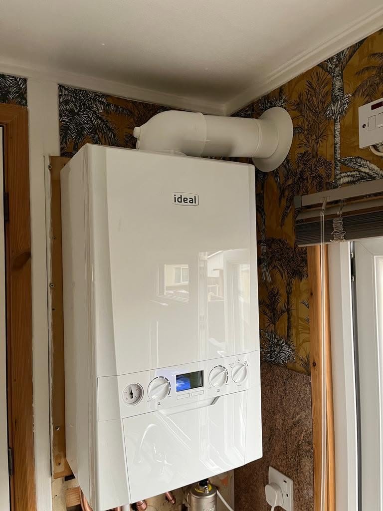A boiler in its new position with the flue run out through the wall and the surrounding wall not yet made good